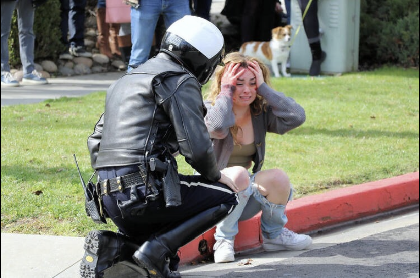 Bella Huyler (19) sits with a police officer in the Every Fifteen Minutes simulation held Thursday, February 28, reminding teens of the horrors that come with drinking and driving.