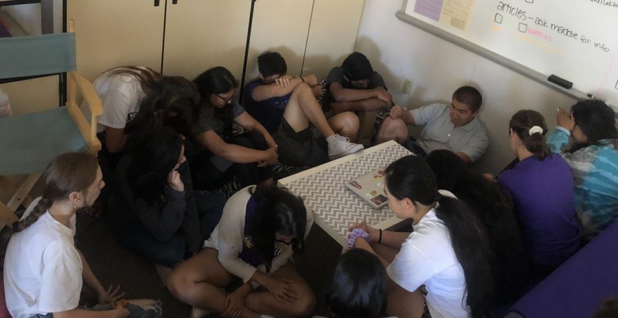 Students crouched together during intruder drill to practice what precautions to take during an emergency. 