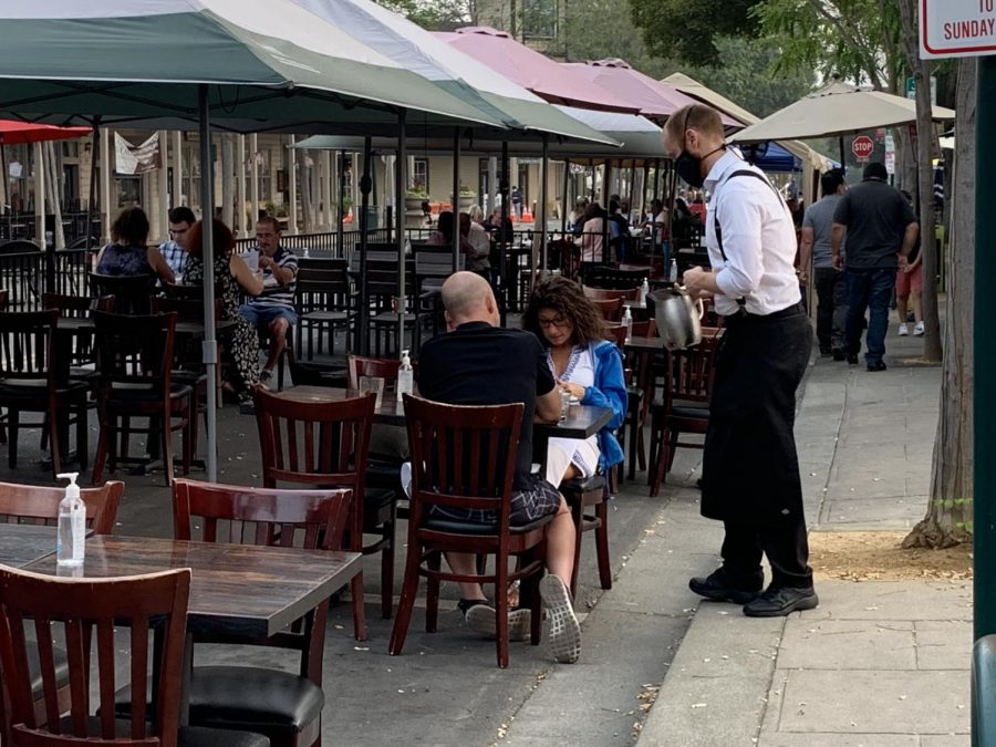Despite Covid-19 and poor air quality, many families opt to dine in the tables set outside downtown restaurants. While eating, the diners do not wear masks, but restaurant staff try to stay safe by serving while wearing masks.