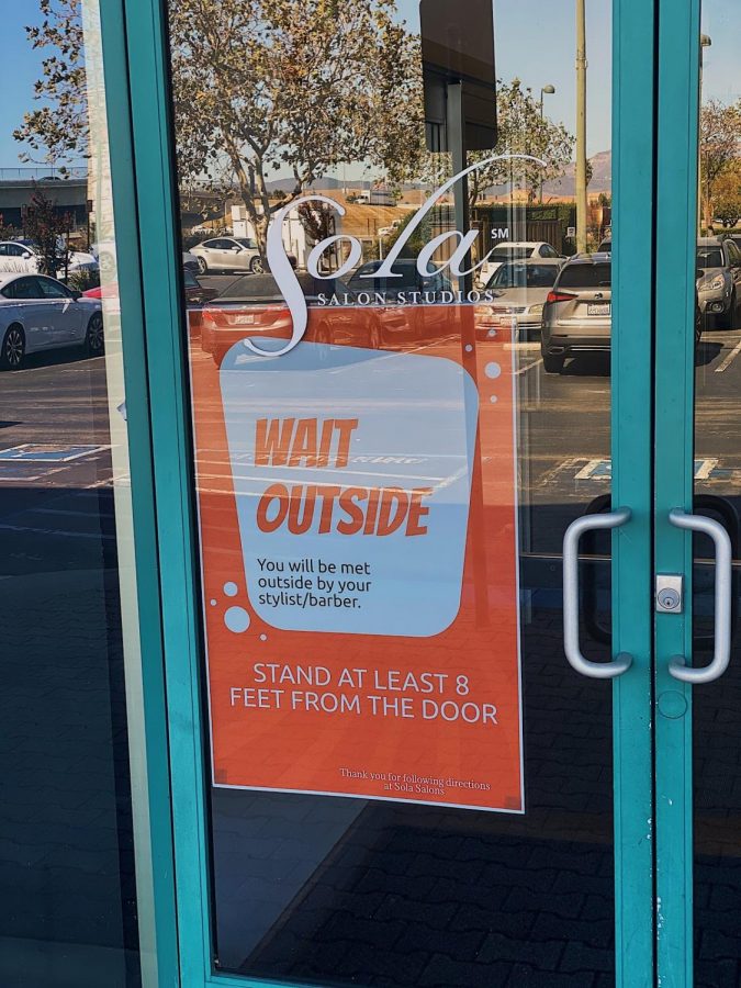 The front doors at Sola Salon Studios in Pleasanton are filled with signs to encourage social distancing to their best ability.
