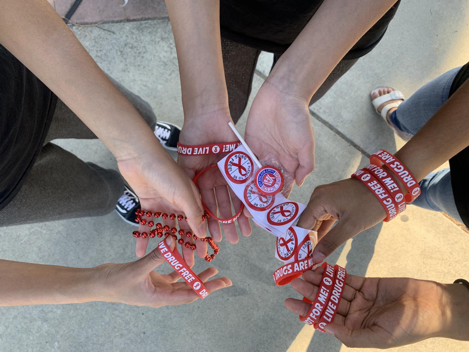 My favorite part of Red Ribbon Week was going to school and handing out items like red wristbands, necklaces, lollipops, and stickers, said peer educator Shreya Sati (22).