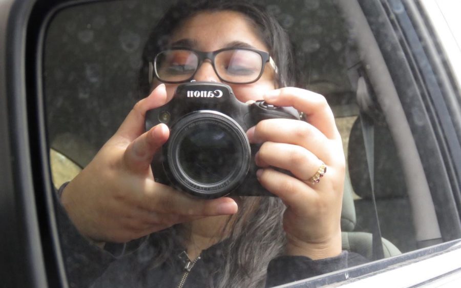 Sporting a camera, a journalism student prepares to photograph an event.