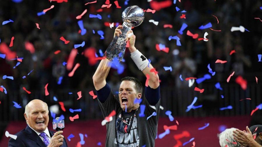 Here Brady holds one of his many Super Bowl trophies for the New England Patriots.