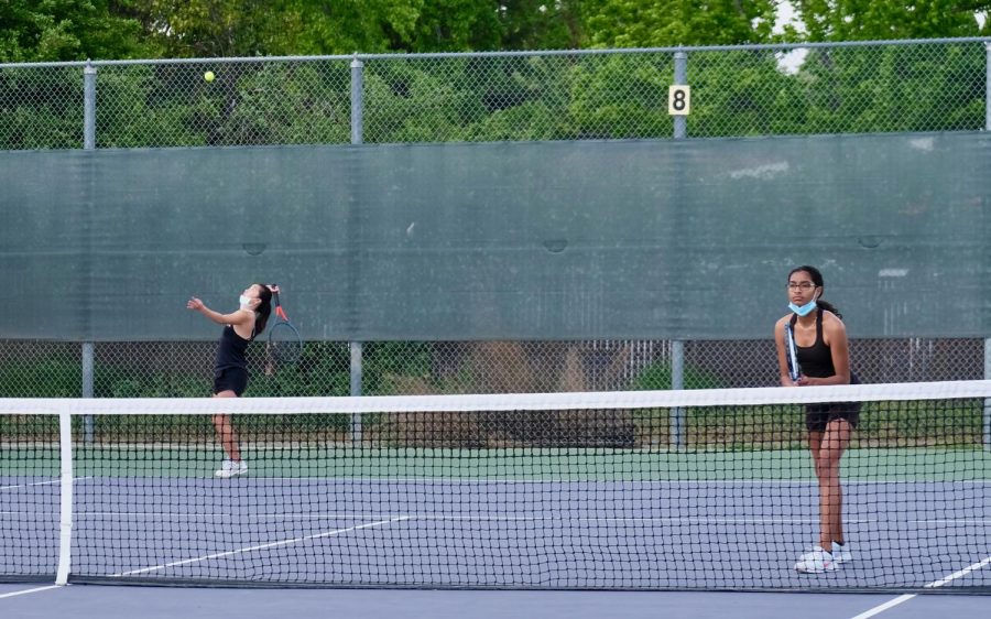 While playing a doubles match, Sarah Yang (23) and Aditi Pattanshetti (23) get ready for their next round with their serve.
