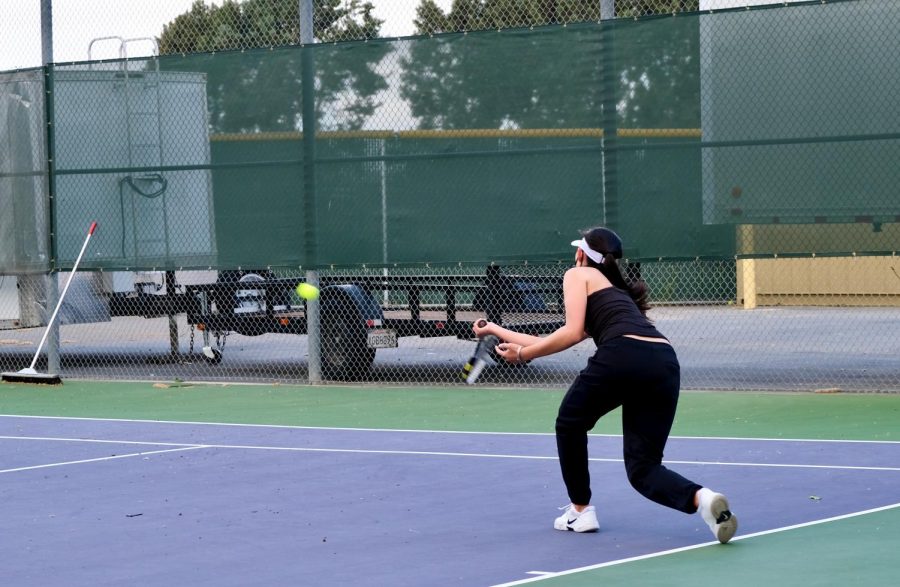 Refusing to lose the point, Amanda Wang (21) leans forward to hit the ball at any cost.
