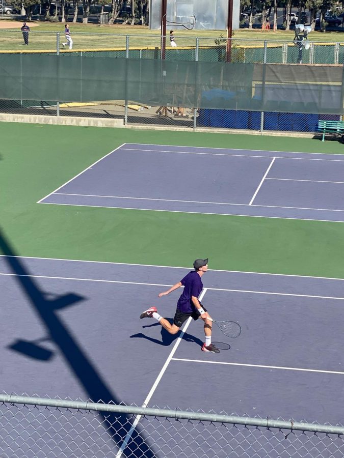 Brett Miller (21), Varsity Singles Player, strides gracefully to return a serve from his Dublin opponent. 