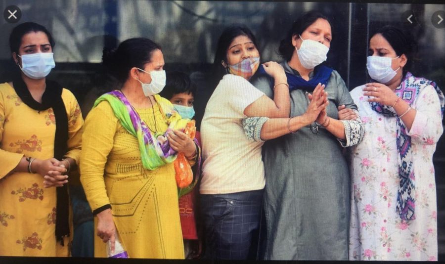 Women watch helplessly as others are taken away to the hospital. Originally posted: BBC News. 