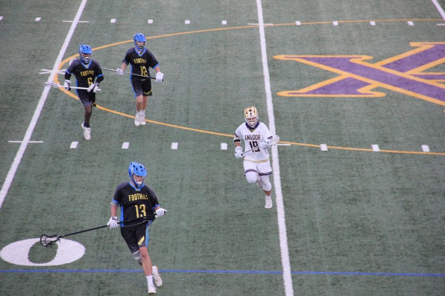 #19 Nick Strain (21) cradles the ball running downfield.
