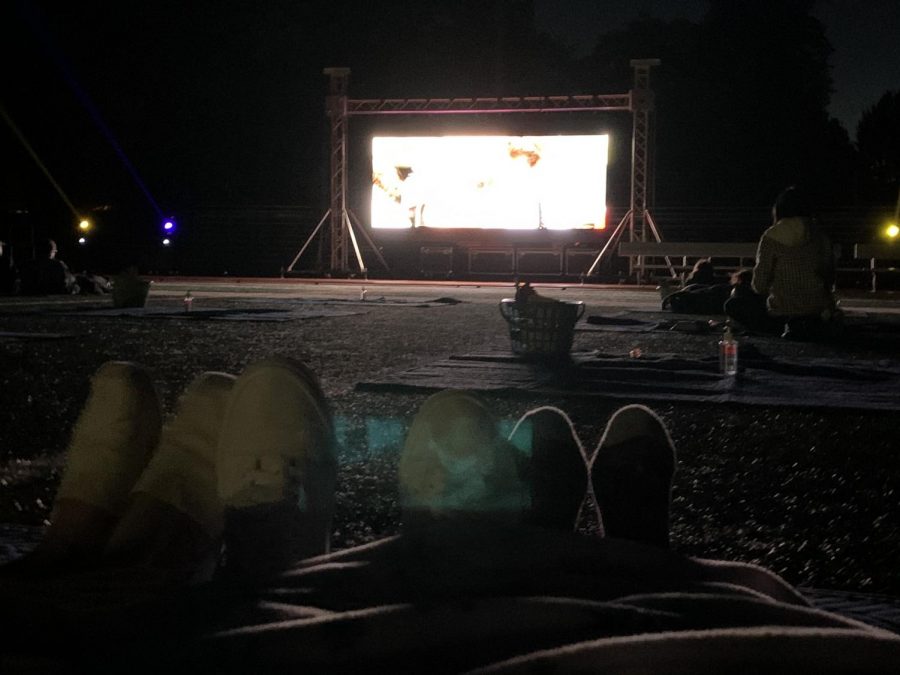 Here, three students lie backward and cover everything but their feet in a blanket as they try to fight off the cold while watching the movie.
