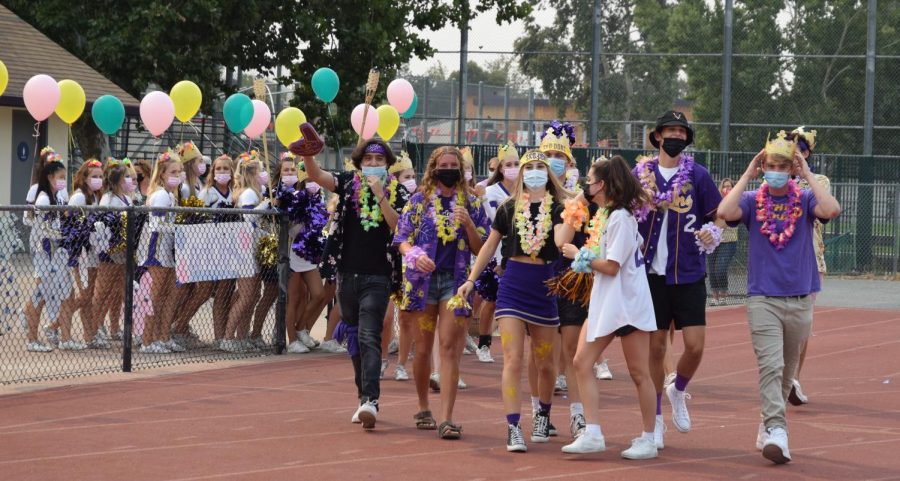 The Varsity Cheer team and the spirit team walk to the stands after welcoming students to the 2021-2022 Aloha Rally. 