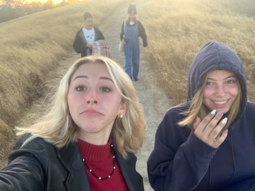 Chloe Pessiner and Rae Kerton joking around as they hike their way back down the hill. 