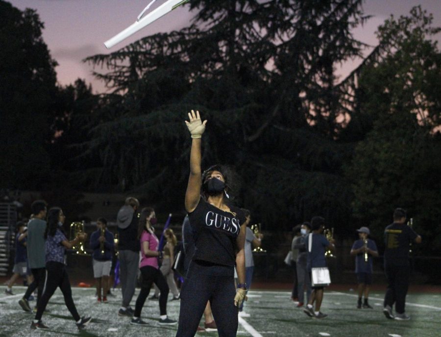 Colorguard member tossing her rifle in the air, clearly demonstrating the saying practice makes perfect.