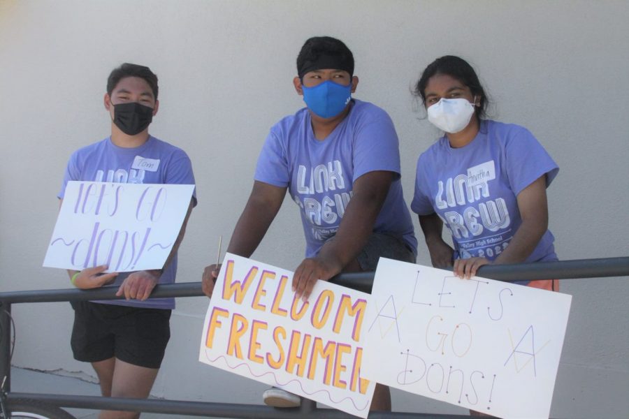 3 Link Leaders welcome the new students by drawing signs.