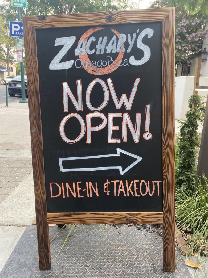 A chalkboard sign on Pleasanton’s Main Street tells the public the restaurant is open for dine-in and takeout.