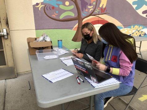 Volunteers get students ready for registration and testing in front of the band room.