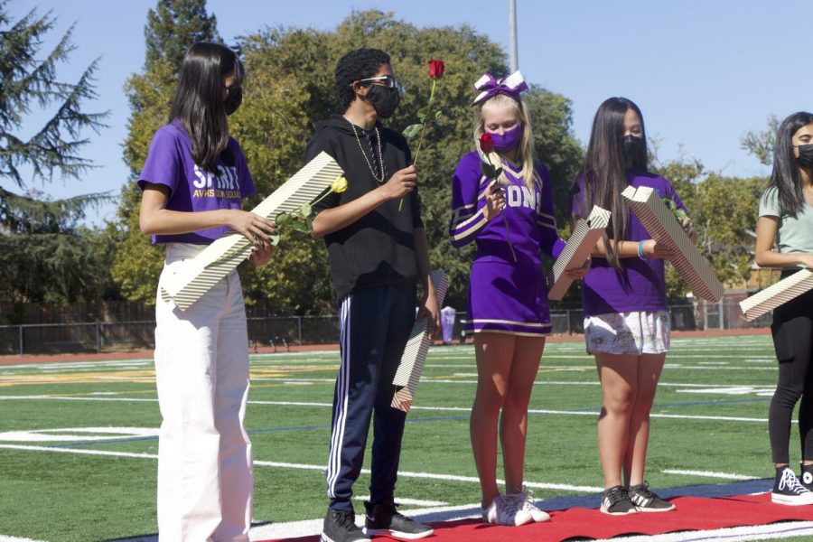 Dons Natalie Kong (24), Jishnu Deep (24), Isabella Wolgraff (24), and Elizabeth Hong (24), who were nominated for homecoming court and royalty, line up to see who gets the red rose, crowning themselves winner.