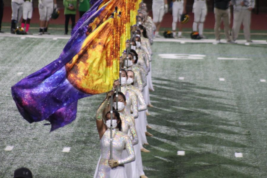 The color guard stands tall as they perform for pre-game, dressed for the football half time show.