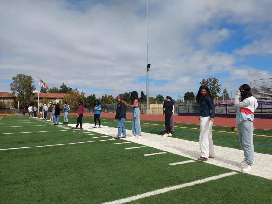 6th+period+Psychology+students+prepare+to+cross+the+field+with+blindfolds+on.