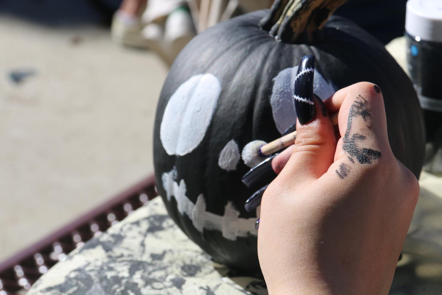 English second language students participate in a pumpkin painting social