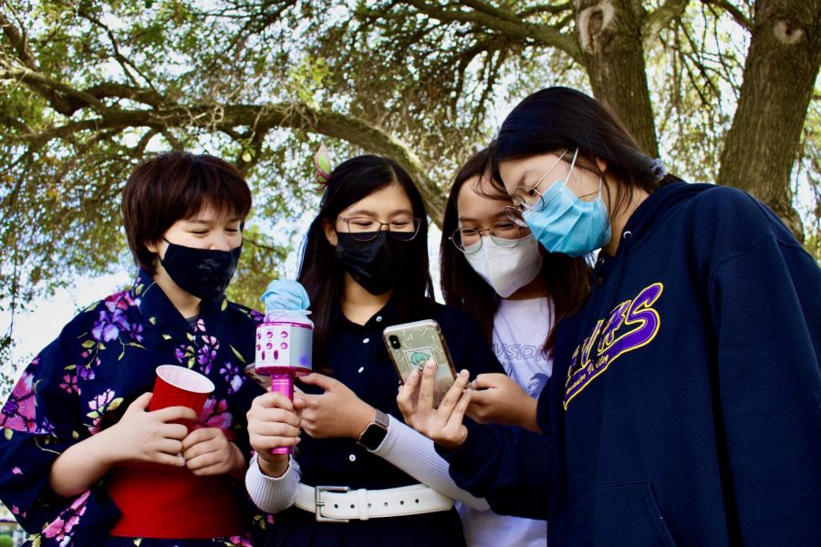 Keira Lai ('24), Suah Oh,('24), Joyce Kuang ('24), and Emi Ray ('25), huddle together while singing Japanese karaoke.
