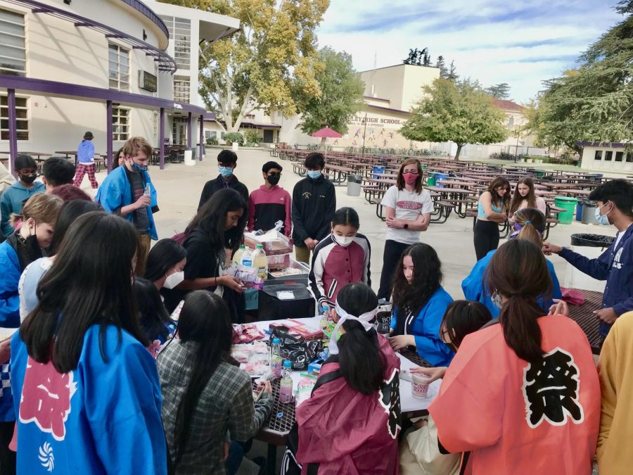 Students gather around the lunch tables, trying traditional Japanese snacks.