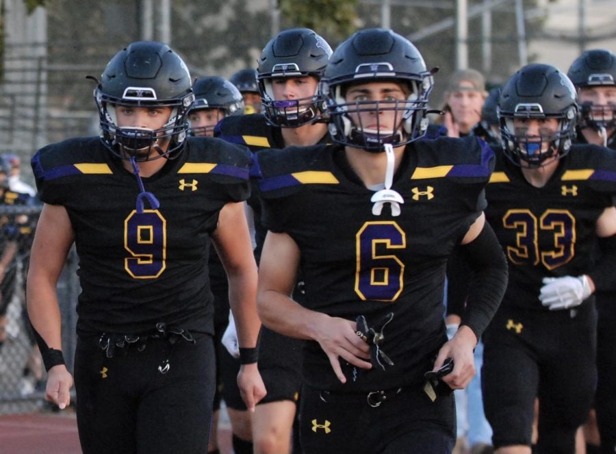 The Amador football squad marches into the track full of spirit.