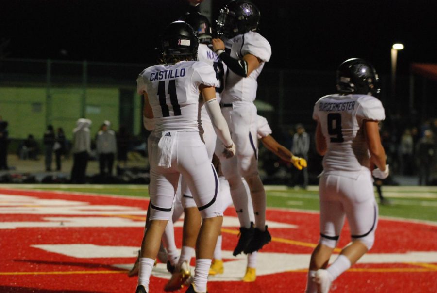 Three football players walk off the field after a successful game. 