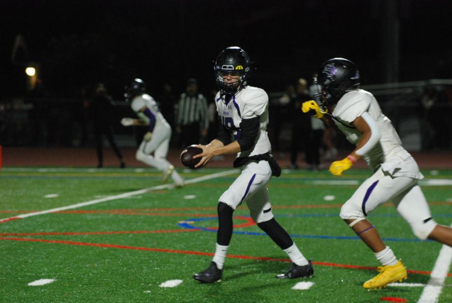 Holding the ball, an Amador player prepares to run as a rival player chases.