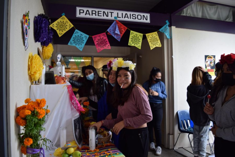 Officers of the Latino Club, Yatziri Hernandez, Yazmin Martinez, and Es Lizeth Barajas, set up the vivid display of symbolic objects for the Altar of the Dead on November 1st. 