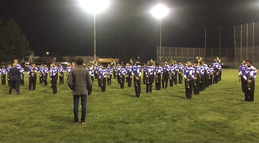 At James Logan, the brass listen to instructions from Mr. Cordoba and other staff during their visual warm up before lining up to perform at finals.