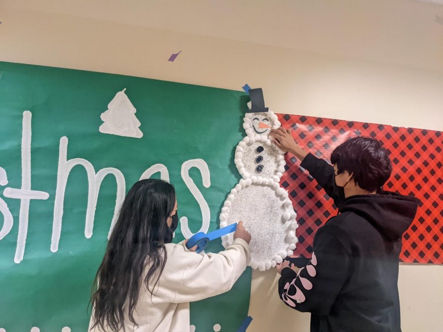 Sara Vannoni ('23) and Logan Bayani ('22) work on making snowman out of cotton balls and paper.