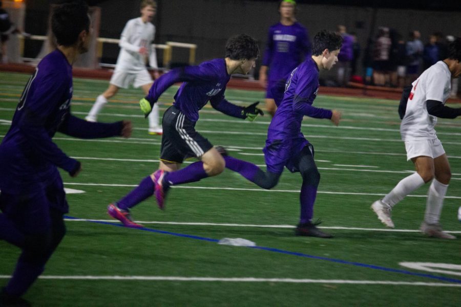 [From left to right] Fionn Conway ('22) and Kyle Larsen ('22) sprint to take control of the ball.