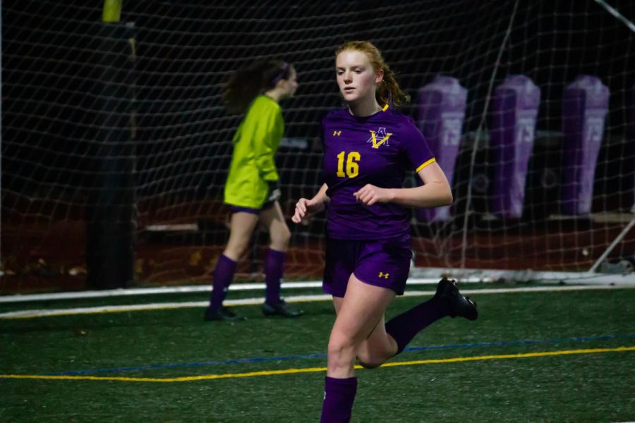 Abigail Hall ('25) sprints as rain falls onto the field.
