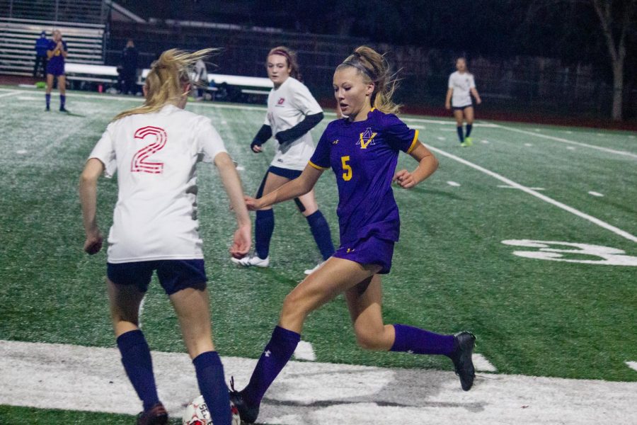 Brooklyn Harmon ('25) bringing the ball down the field trying to get past the defense.