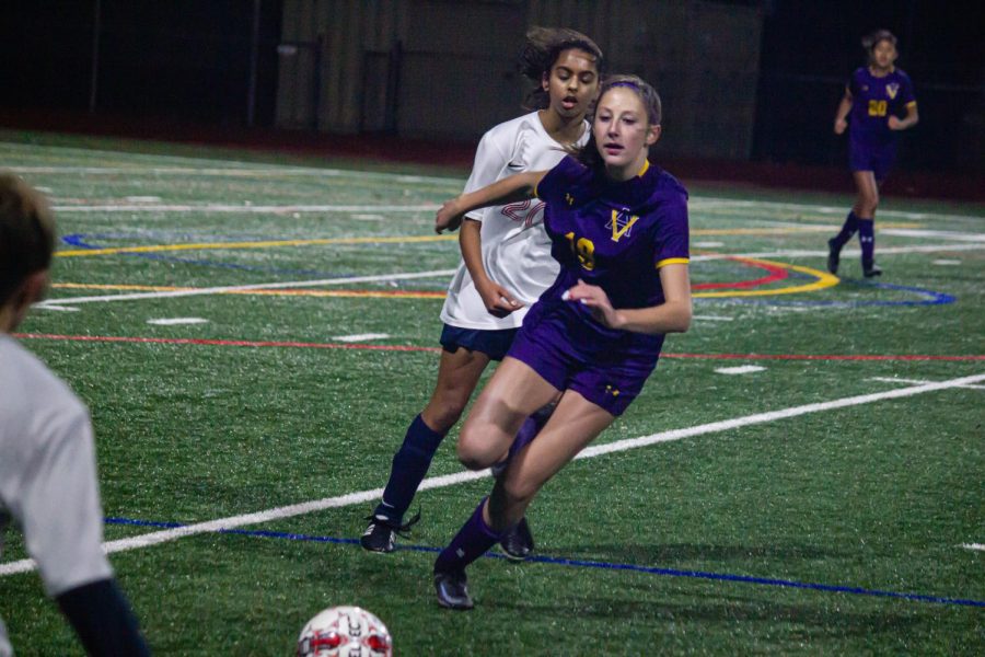 Hailey Rice ('25) defends against a Dublin player while preparing to score a kick.
