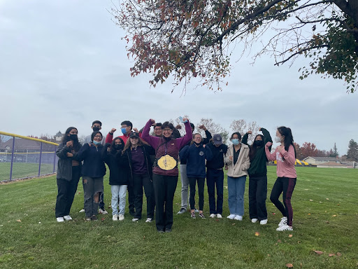 The 2021-2022 team poses with the belt proudly outside their classroom, overwhelmed with joy from their first real victory.