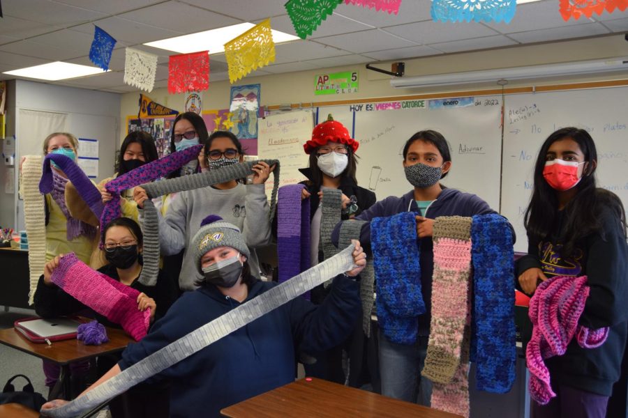 From left to right, Mrs. Henriquez, Alice Lee (23), Marina Wang (23), Joanna Chu (23), Arya Deshpande (23), Kaitlyn Hekl (23), Victoria Liu (23) and Janani Prasad (23) stand in a group photo holding up their creations.