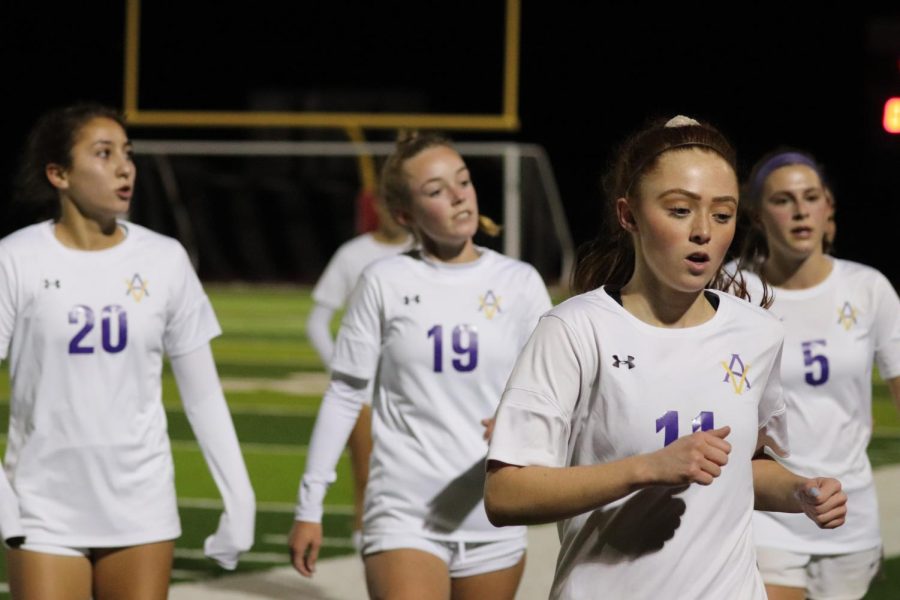  Kylie Beeby (‘22) and her teammates jog off the field to talk with the team about strategies to take home the win.