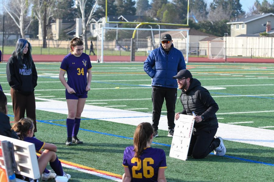 The coach talks to Amador players about defenses during half time.
