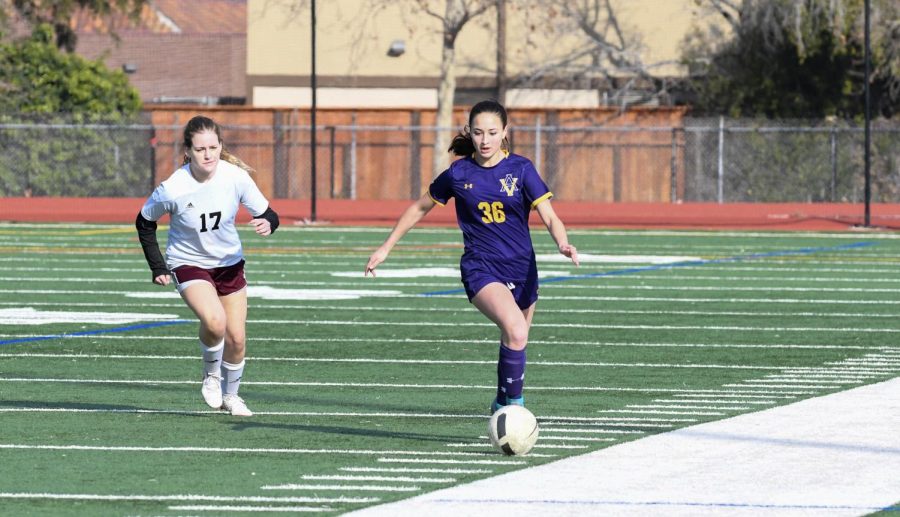 Maddie Flasck (‘23) carries the ball down the field with control.