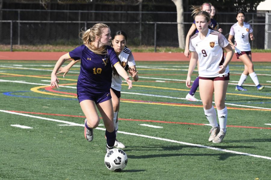 Maddie Benson (22) tries to protect the ball and gets away from defense players.