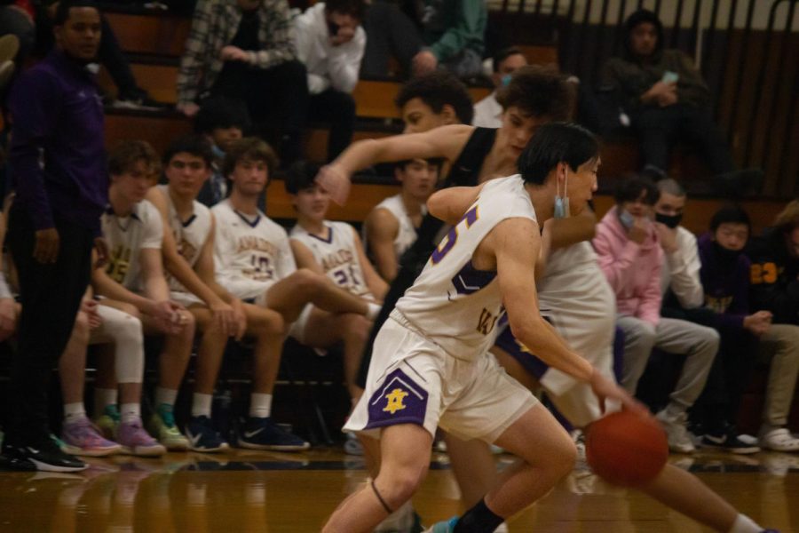 Jesse Huang ('23) dribbles the ball as a rival player tries to intercept.