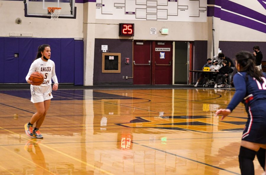 Arissa Leomiti ('22) dribbles the ball as she crosses the center line.
