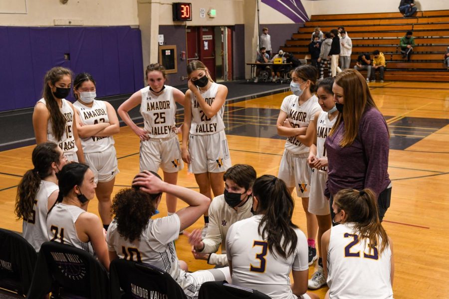 The coach discusses some plays with the team during half time.