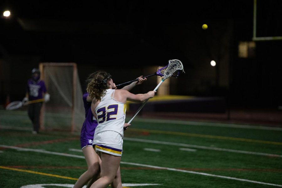 Lily Keegan ‘23 fights for possession of a passed ball.