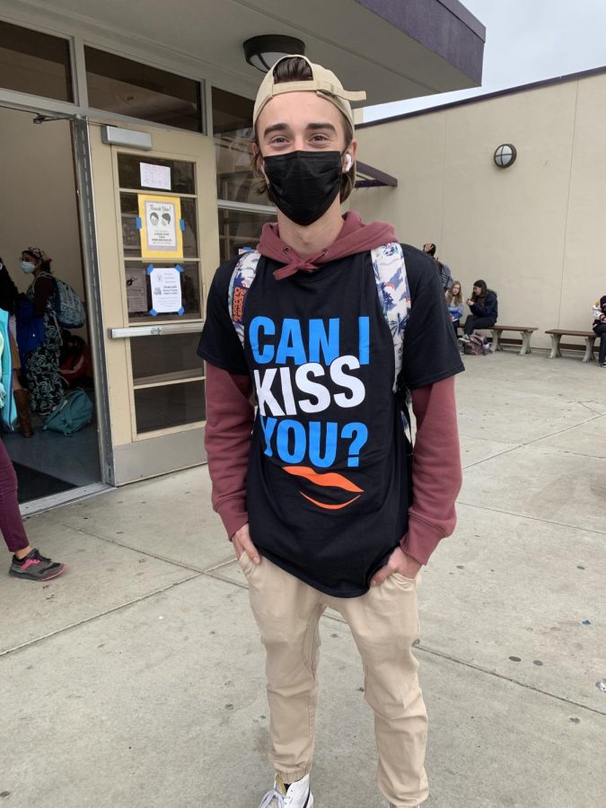 Terrence Moore ('23) poses in a "Can I kiss you?" t-shirt he won from participating in the assembly.