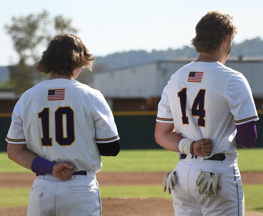 Blake Bouchard (22) and Ethan Jackson (23) pledge to the flag before the game starts.