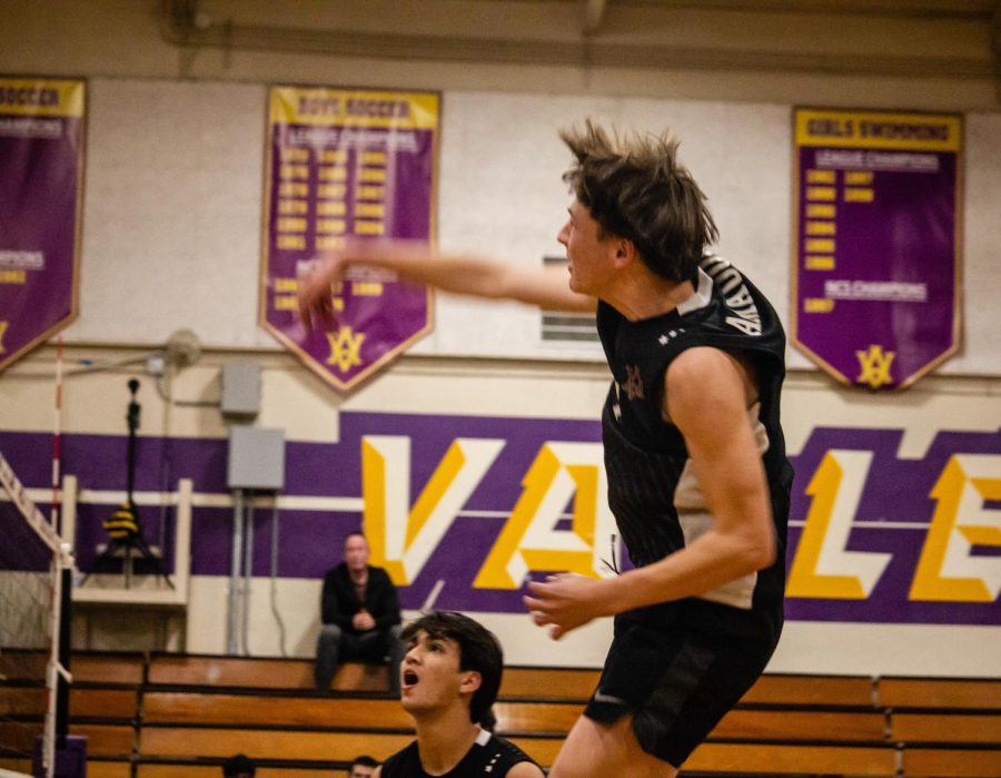Tyler Homes ('23) slams the ball over the net.