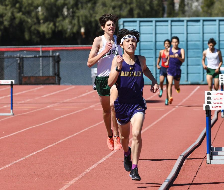 Ryken Mak (23) wins first in his heat in the 1600 meters.