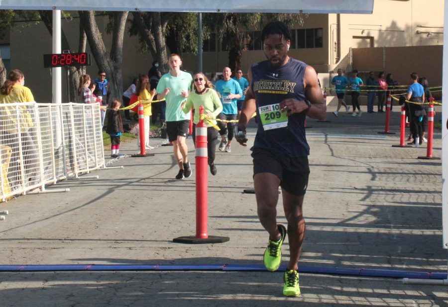 One of the first few participants of the 10K race passes through the finish line.